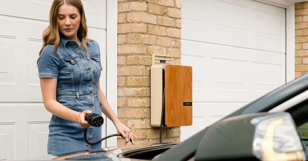 Femme branchant sa voiture électrique sur une borne de recharge murale